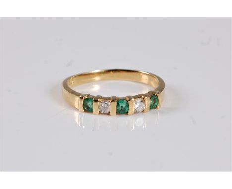 An 18ct emerald and diamond ring, the three small round emeralds interspaced with a round diamond, with a plain band stamped 