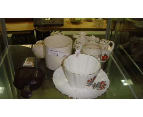 Shelf of crested ware including Goss, models including Cannon, tea cup, plated and leather bound hip flask etc.