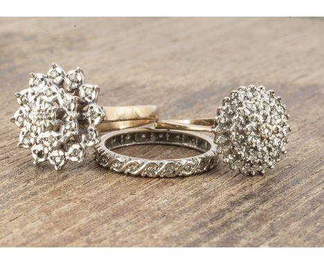 Three gold diamond set dress rings, including a full eternity ring size L, and two 9ct gold cluster rings, ring size J and K,