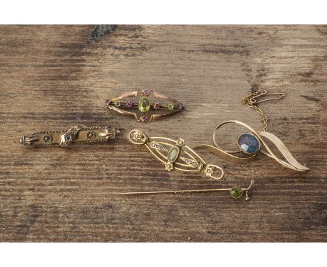 A collection of gold and yellow metal brooches, including a 9ct gold peridot stick pin, peridot and seed pearl brooch, opal d