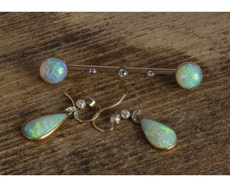 An Edwardian suite of opal jewels, including a pair of drop earrings, the tear shaped emeralds supported on old cut diamond c