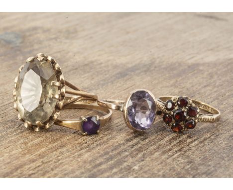 Four 9ct gold gem set rings, including  a pale amethyst, oval cut ring size I, citrine example ring size K, a garnet ring siz