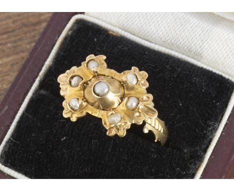 A continental yellow metal and seed pearl dress ring, the shaped tablet top set with half cut pearls measuring 1.8cm x 1.2cm,