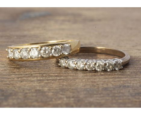 Two diamond seven stone set rings, all claw set brilliant cuts, one with a flange edge, one ring size R having 0.63cts, other