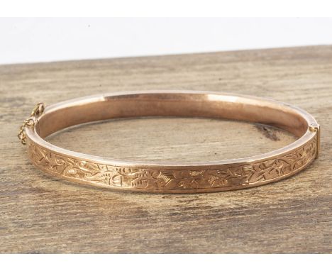 An oval 9ct gold bangle, with engraved top, hinged, 5.4 cm by 6.2 cm, 7.8g 