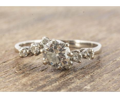 A diamond solitaire crossover ring, in 18ct setting, the brilliant cut in six claw setting, with diamond set shoulders, on pl