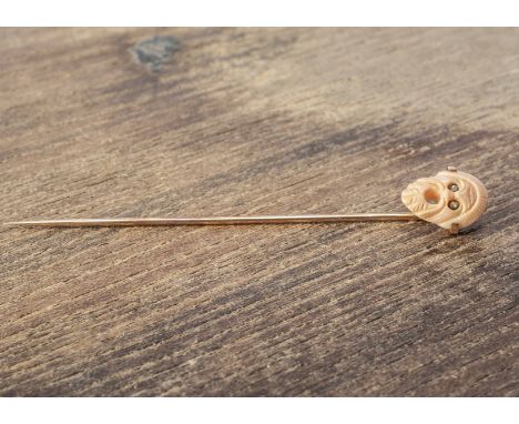 A 19th Century coral and diamond stick pin, the gold pin surmounted with a coral Greek tragedy mask with rough cut diamond se
