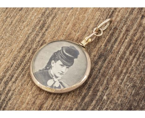 An Edwardian 9ct gold circular openwork locket, with a portrait of a woman in mourning, the reverse with a panel of plaited h