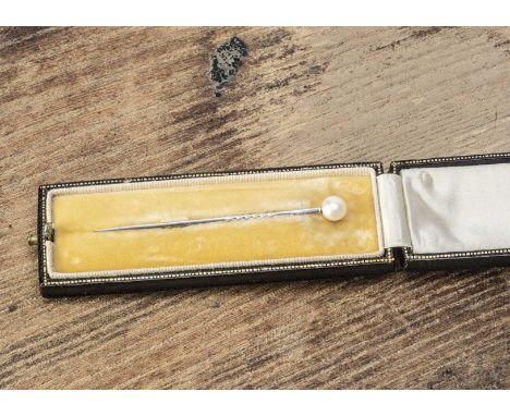 An early 20th Century pearl stick pin, the platinum square and twisted pin supporting a possibly natural pearl, within a fitt