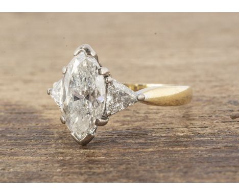 A marquise cut diamond solitaire, flanked by two trillion cut diamond shoulders, all in white metal mount on a yellow 18ct go