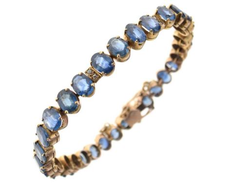 Sapphire and diamond bracelet, stamped '14c', the thirty-one oval cut blue sapphires, punctuated in five places with pairs of