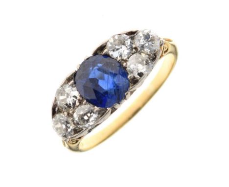 Sapphire and diamond ring, stamped ‘18ct’, the oval cut sapphire flanked either side by a trio of diamonds, the six old brill