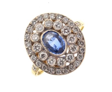 Sapphire and diamond cluster ring, stamped '18ct', the oval cut sapphire enclosed by two rows of small brilliant cut diamonds