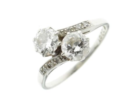 Two stone diamond crossover ring, stamped 'Fine Plat' and numbered '3301', the brilliant cuts of approximately 0.52 and 0.56 