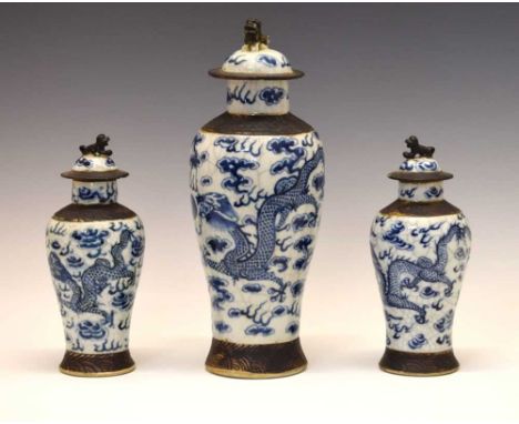 Garniture of three Chinese porcelain crackleware baluster jars and covers, each decorated with four-clawed dragons chasing th