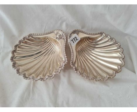 A large matching pair of George III butter shells with gadrooned borders on scallop feet - 6.5" wide - London 1771 one by EA 