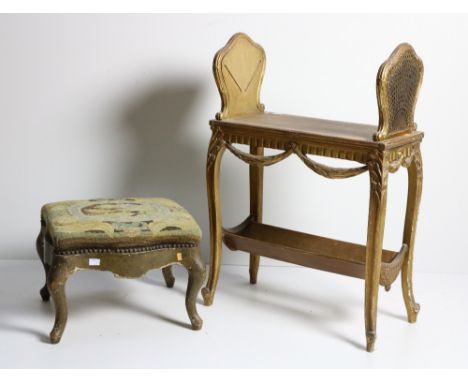 A 19th Century French two tier giltwood Book Trough, with shaped and wicker work sides over a frieze with draped garlands, on