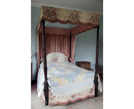A 19th Century mahogany four poster double Bed, with floral pink tapestry drapes supported by turned and reeded pillars, appr