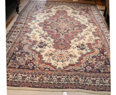 A large woolen Carpet, the cream centre with diamond shaped design and large border, approx. 330cms l x 236cms w (10'10" x 7'