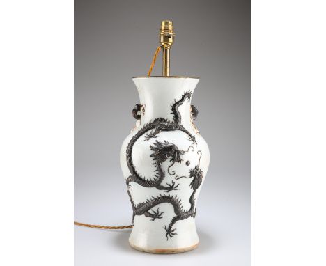 A CHINESE PORCELAIN TABLE LAMP, vasiform, moulded in relief with dragons chasing a pearl, bears marks. 45cm to top of fitting