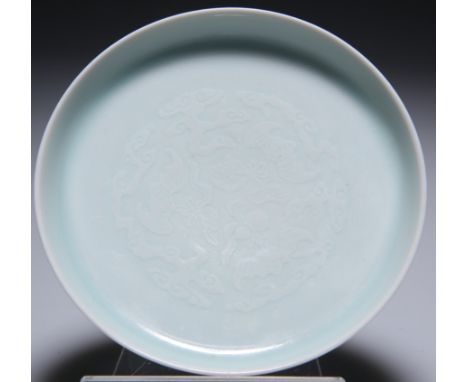 A SMALL CHINESE CELADON SAUCER DISH, circular with collet foot, decorated with bats, lingzhi clouds and gourd flask, the unde