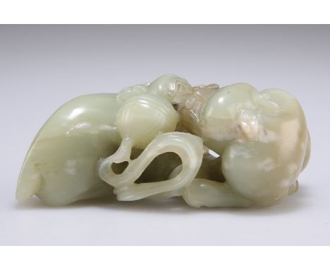 A CHINESE JADE CARVING OF LION DOGS, the two mythical beasts carved playing with a brocade ball, the stone of celadon colour.