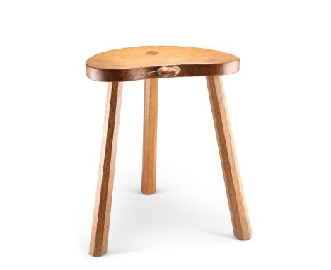 ROBERT THOMPSON, A MOUSEMAN OAK MILKING STOOL, the kidney shaped adzed seat raised on three faceted legs, with carved mouse s