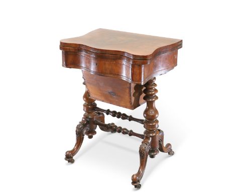 A VICTORIAN WALNUT GAMING AND SEWING TABLE, the foldover top of serpentine outline, opening to reveal an inlaid playing surfa