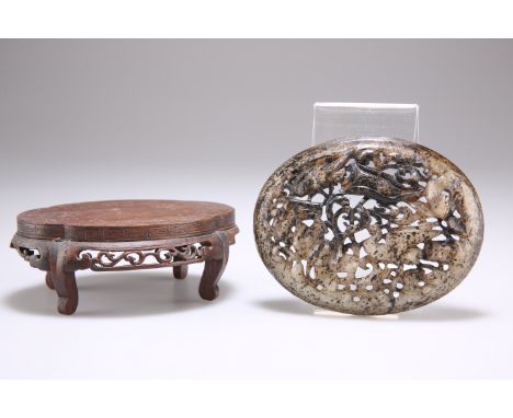 A CHINESE JADE PLAQUE, convex oval, celadon with black/brown varying inclusions, carved and pierced with birds and foliage, o