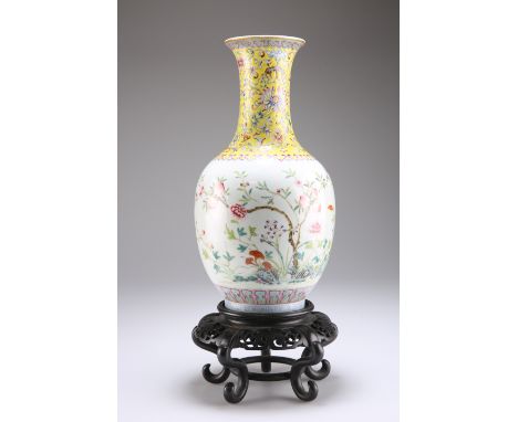 A CHINESE FAMILLE ROSE PORCELAIN VASE, of baluster form with high flared neck, enamel painted with fruiting boughs and rockwo
