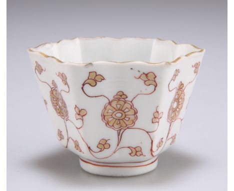 A CHINESE PORCELAIN WINE CUP, KANGXI, tapering hexagonal form with collet foot, iron red painted and gilded with sinuous tend