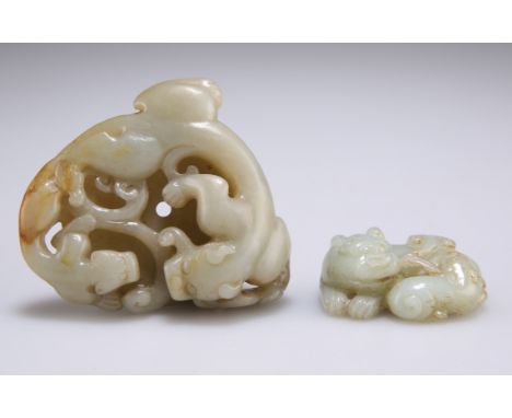 TWO CHINESE JADE CARVINGS, the first a disc depicting a chilong with its young, 6.8cm wide; the second a shishi with young, 4