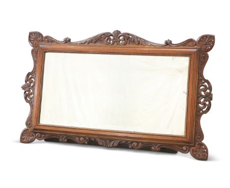A 19TH CENTURY CONTINENTAL CARVED WALNUT MIRROR, with rectangular bevelled mirror-plate, the pierced surround carved with pal