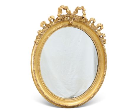 A 19TH CENTURY GILT-GESSO OVAL MIRROR, with ribbon-tied crest. 83cm high, 64cm wide