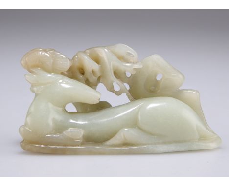 A CHINESE JADE "DEER" CARVING, of a recumbent stag beneath a leafy tree, the stone of pale celadon colour. Base 8.2cm by 3.5c