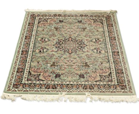 A TURKISH HAND-KNOTTED SHIRAZ RUG, the green field with black medallion and corners surrounded by figures hunting on horsebac