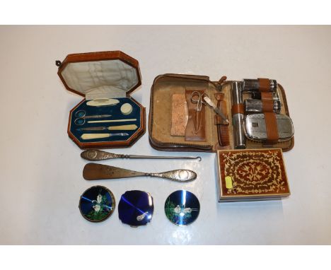 A silver handled button hook and shoe horn; a cased set of vanity items; a travelling toilet set; and a musical trinket box a