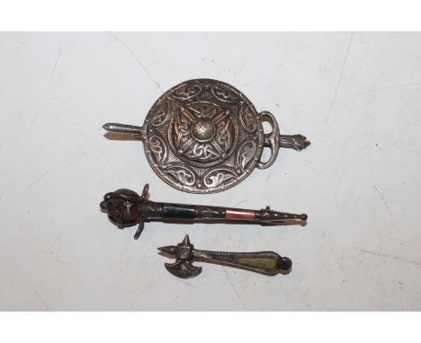 A silver shield brooch; a Scottish white metal and stone set brooch in the form of a sword and a similar brooch in the form o