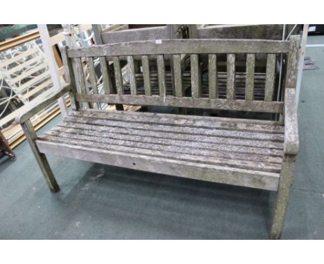 A well weathered teak garden three seater bench 
