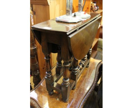 A reproduction oak twin flatp coffee table, single gate leg action on turned and blocked legs 