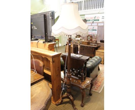A carved wooden standard lamp with tasselled shade 