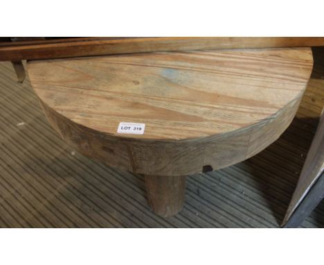 A rusticated circular topped coffee table on four cylindrical trunk like legs 