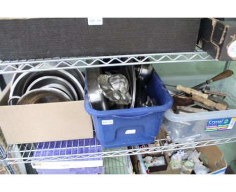 A shelf full of predominantly stainless steel catering equipment to include cutlery and preparation tools 