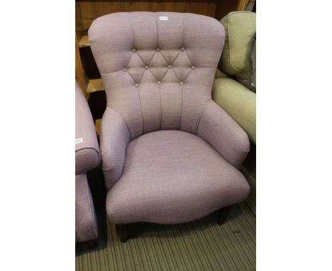 A lavender upholstered button backed Laura Ashley low seated armchair, with show wood legs 