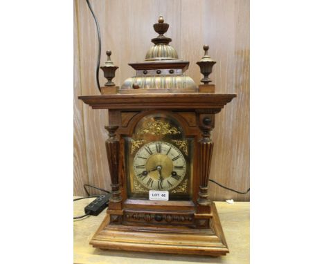 A late 19th / early 20th century continental walnut cased mantel clock of architectural form, with pendulum and key 