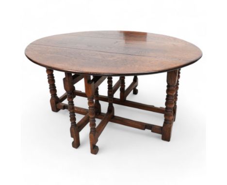 17th century design oak dining table, oval drop-leaf top over double gate-leg action base, on turned supports united by stret