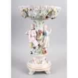 A Continental porcelain table centre, the stem decorated with two figures and floral decoration to
