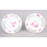 A pair of bone china plates with puce cherub and floral decoration with pierced borders, 9 1/2" dia