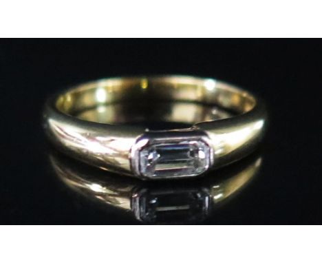 An 18ct Gold and Baguette Cut Diamond Solitaire Ring, size M.5, 3.9 g