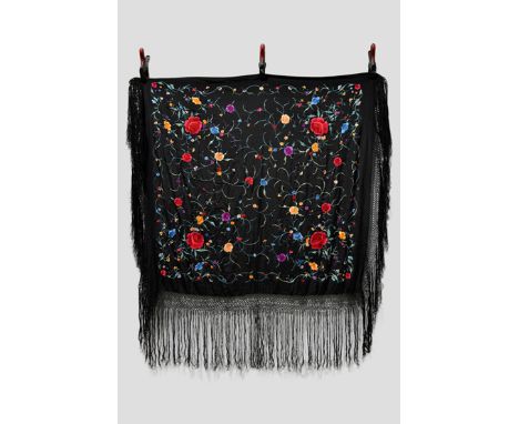 Two Chinese black silk square shawls, both embroidered in brightly coloured silks, the first with all over flowers and foliag
